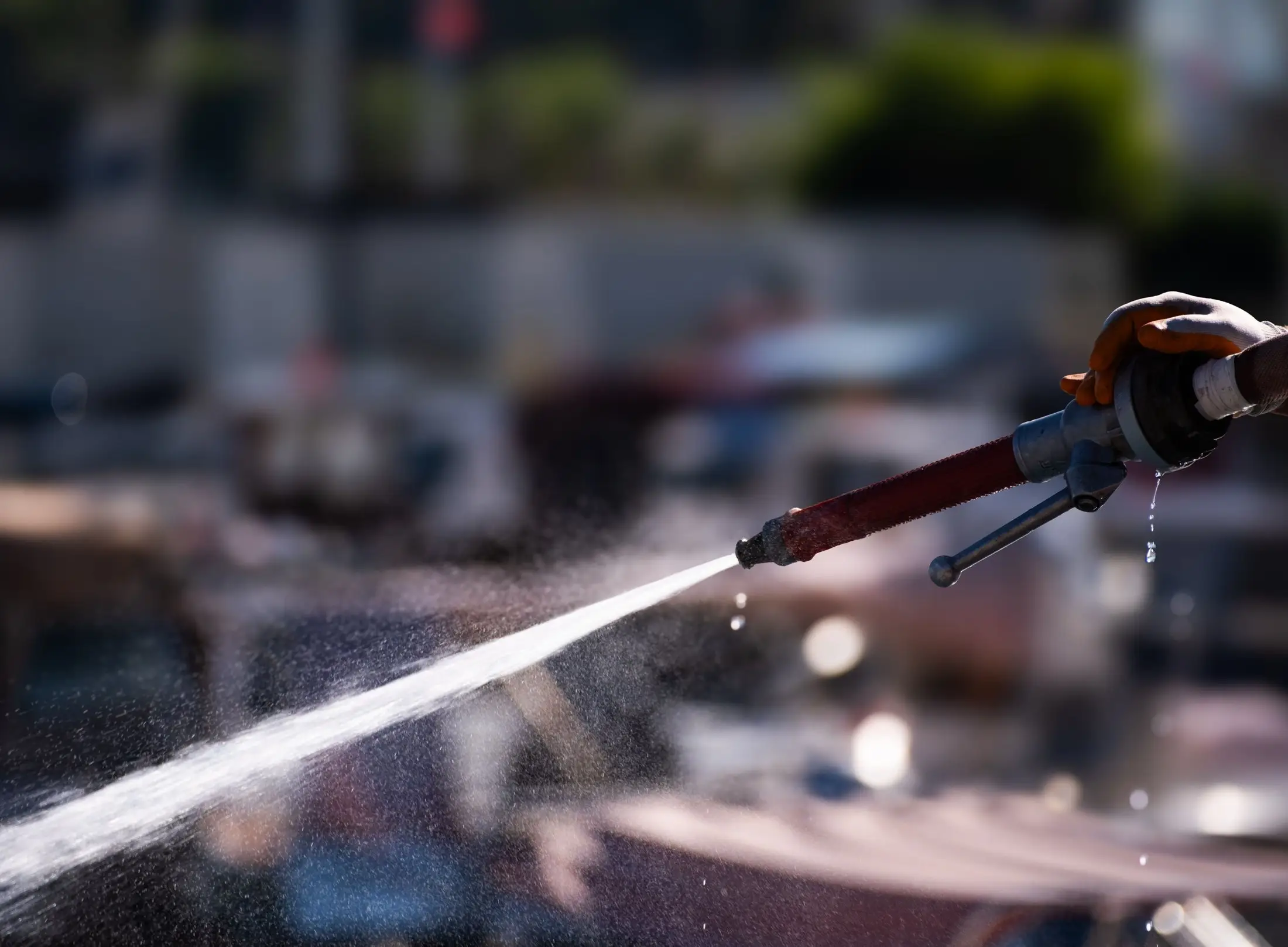 Main gantée tenant une lance qui projette un jet d'eau